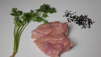 peitos de frango são considerados um alimento universal. é preparado pronto para cozinhar com coentro e pimenta-do-reino para dar um toque picante. caiu mostrando a textura saltitante da carne. video