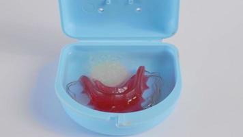 Retainer is placed in a water container and effervescent tablets are added to the water to create bubbles. In order to clean the retainer, we have to put it in our mouth because we have braces. video