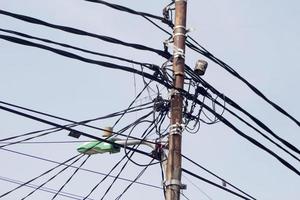 foto de un poste eléctrico con cables enredados