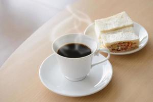 hot coffee with sandwich on wooden table photo