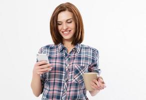 mujer morena feliz con una camisa a cuadros usando un teléfono móvil aislado en un fondo blanco. foto