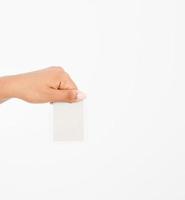 hand hold blank business card. female arm hold paper isolated on white background. copy space. mock up.