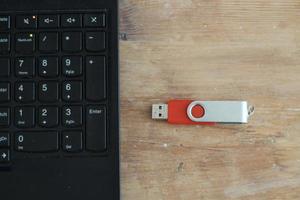USB stick on table next to laptop photo