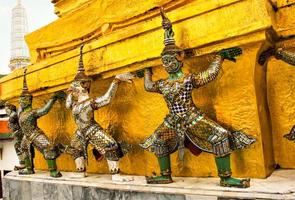 Giant Sculpture around the base of the golden pagoda in Wat Phra Kaew photo