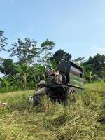 rice milling machine in rice field photo