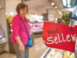 las ancianas asiáticas miran la zona de los mejores vendedores en el supermercado foto