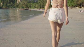 shot van jonge sexy vrouw die alleen op het strand van het eiland loopt, zomerontspanning, kalm en vredig strand, ecologische reisomgeving behoud duurzaamheid van de natuur, tropisch eiland video