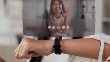 Close up hand of woman pressing buttons on the smartwatch and chatting on a video call. Young female talking to friend. Projecting visible AR screen, technology, future and futuristic concept.