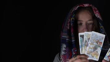 chica joven con una bufanda que muestra las cartas del tarot video