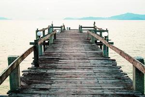 una pasarela de madera que se adentra en el mar. concepto de viaje de vacaciones foto