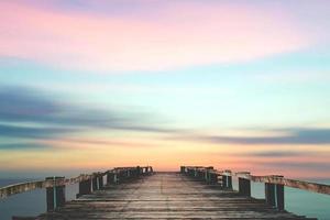 A wooden bridge jutting out into the sea with a beautiful view. photo