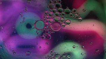 huile alimentaire colorée abstraite gouttes bulles et sphères coulant sur la surface de l'eau, vidéographie macro