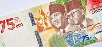 un nuevo billete de 75.000 rupias del banco indonesia con fondo gris. emitido durante la 75ª independencia nacional de indonesia el 17 de agosto de 2020, período de 1945-2020. moneda indonesia. foto