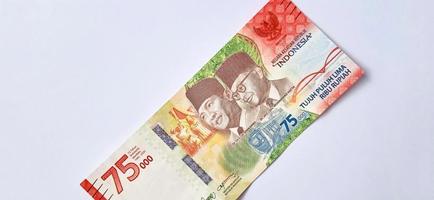 un nuevo billete de 75.000 rupias del banco indonesia con fondo gris. emitido durante la 75ª independencia nacional de indonesia el 17 de agosto de 2020, período de 1945-2020. moneda indonesia. foto