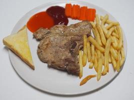 T-bone steak pork with vegetable salad, Toast and French fries on white plate food cooked for eat