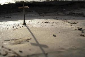a Christian cross standing alone in the sand