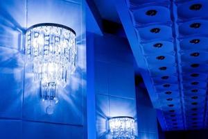 blue background with crystal chandeliers on the walls photo
