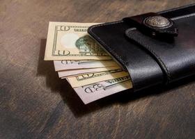 leather wallet with money and cards lying on the table photo