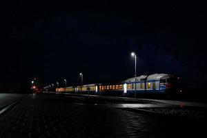 train on the railway platform of the station at night photo