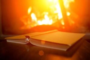 open book on the background of a burning fireplace photo