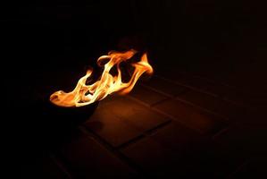 fire burns in a bowl on the ground photo