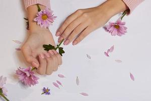arte de la moda cuidado de la piel de las manos y flores rosas en manos de las mujeres foto