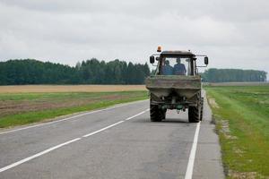 tractor rides on the road rear view photo