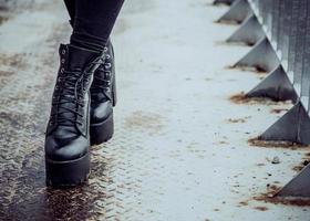 Women's legs in ankle boots on the iron bridge photo