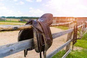 sillín de caballo colgado en un primer plano de la cerca foto
