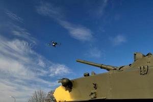 el tanque apunta con un arma al dron. drones de combate y cuadricópteros foto