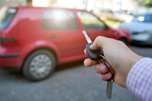 key in hand on blurred car background photo