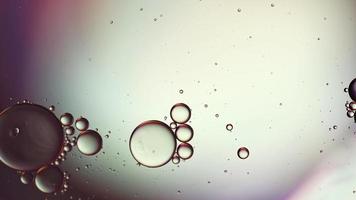 abstracte kleurrijke voedselolie druppels bubbels en bollen stromen op het wateroppervlak, macro videografie video