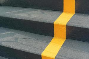 The stairway of the overpass with yellow line of lane and railing for road crossing safety. walk sign on ladder. Yellow cross on stairs. photo