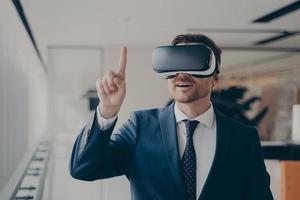 Smiling bearded businessman in 3d goggles using augmented reality in work photo