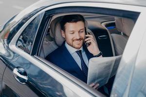 Elegant businessman in formal stylish wear traveling in luxury car photo