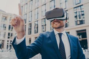 Businessman in formal blue suit using VR glasses outside photo