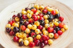 imagen de cerezas maduras frescas en un tazón. cerezas blancas y rojas. alimentación saludable. frutas de temporada. concepto de nutrición alimentos crudos foto