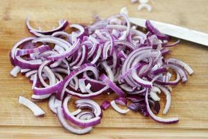 red onions on wooden cutting board photo