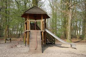 parque infantil forestal con cabaña de madera y tobogán foto