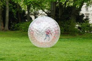 niño irreconocible zorbing en el parque foto