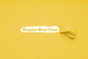 texto de feliz año nuevo sobre fondo de papel amarillo foto