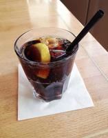 cola with lemon slice and ice cubes photo