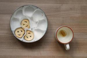 taza de café vacía y lata de galletas foto