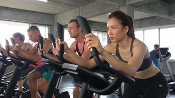 group of people in gym, exercise on bicycle together. video