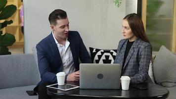 deux jeunes collègues discutant ensemble pendant une pause. groupe de gens d'affaires en démarrage travaillant au quotidien dans un bureau moderne. video