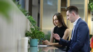 Two young colleagues chatting together on a break. startup business people group working everyday job at modern office. video