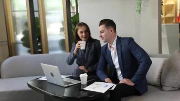 deux jeunes collègues discutant ensemble pendant une pause. groupe de gens d'affaires en démarrage travaillant au quotidien dans un bureau moderne. video