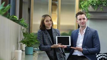 dos jóvenes colegas charlando juntos en un descanso. grupo de personas de negocios de inicio que trabajan todos los días en la oficina moderna. video