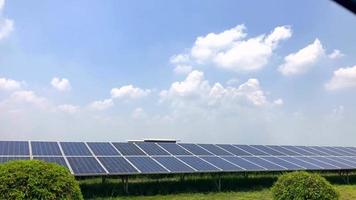 tecnico e investitore che camminano nella fattoria delle celle solari attraverso il campo dei pannelli solari controllando i pannelli nell'installazione di energia solare. le celle solari saranno un'importante energia rinnovabile del futuro. video