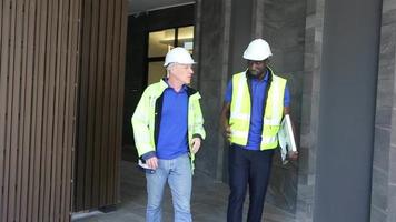 Ingenieros técnicos de trabajadores de fábrica que muestran y verifican el panel de células solares en busca de tecnología sostenible con traje de trabajo y casco. concepto instalar construcción panel fotovoltaico energía renovable. video